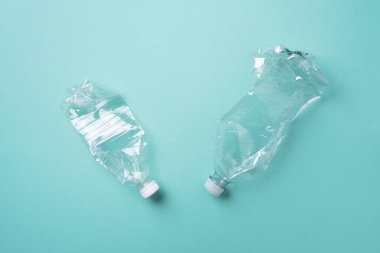 Mavi arka planda plastik şişeler. Üst Manzara. Plastik geri dönüşümü, atık kirliliği konsepti. Üst görünüm, boşluğu kopyala. Çevre koruma kavramı. Çöpü tekrar kullan, plastiksiz. Dünya, dünya su günü.