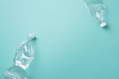 Mavi arka planda kırışık kullanılmış plastik şişe. Üst görünüm, boşluğu kopyala. Kirlilik, çevre koruma kavramı. Çöpü, geri dönüşümü, plastiği yeniden kullan. Dünya, dünya su günü.