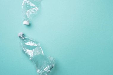 Mavi arka planda plastik şişeler. Üst Manzara. Plastik geri dönüşümü, atık kirliliği konsepti. Üst görünüm, boşluğu kopyala. Çevre koruma kavramı. Çöpü tekrar kullan, plastiksiz. Dünya, dünya su günü.