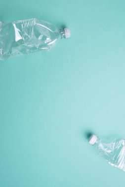 Mavi arka planda kırışık kullanılmış plastik şişe. Üst görünüm, boşluğu kopyala. Kirlilik, çevre koruma kavramı. Çöpü, geri dönüşümü, plastiği yeniden kullan. Dünya, dünya su günü.