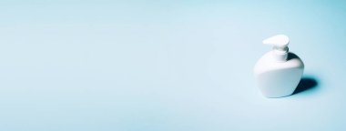 Mavi arka planda beyaz sabun şişesi. Uzayı kopyala Kırpma yolu olan güzellik konteynırını kapat. Salgın sırasında güvenli kalacak ürünler. Covid19 karantina sırasında.