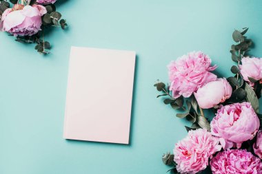 Arkaplanda gül çiçekleri ve tahta tahtalara yazılmış boş not defterleri var. Dikey. Mesaj için yer. Kopyalama alanı olan üst görünüm