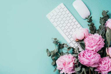 Beyaz klavye, defter ve şakayık, okaliptüs çiçeği, mavi arka planda kopya alanı olan ofis çalışma alanı. Kadınsı çalışma alanı. Düz yatıyordu. Blogger, iş konsepti. Model yap. Doğum günü, Kadın Günü