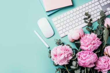 Beyaz bilgisayar klavyesi, fare, şakayık çiçekleri, mavi arka planda okaliptüs çiçekleri. Üst Manzara. Uzayı kopyala Düz yatıyordu. Kadınsı çalışma alanı. Blogger, iş konsepti. Model yap. Doğum günü, Kadın Günü