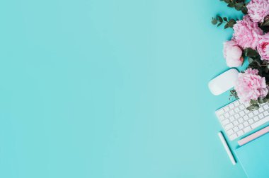 Kadınsı çalışma alanı. Beyaz bilgisayar klavyesi, fare, şakayık çiçekleri, mavi arka planda okaliptüs çiçekleri. Üst Manzara. Uzayı kopyala Düz yatıyordu. Blogger, iş konsepti. Model yap. Doğum günü, Kadın Günü