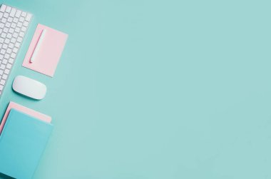 Beyaz fare, klavye, defter, mavi arka planda kalem. Üst Manzara. Uzayı kopyala Düz yatıyordu. Uzaktan kumanda, iş. Merkez ofis çalışma alanı. Kadınsı çalışma alanı. Blogger, iş konsepti. Model.