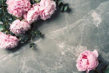 Çiçek deseni, pembe şakayıklardan yapılmış çerçeve, mermer arka planda okaliptüs çiçekleri. Düz yerde, üst tarafta. Uzayı kopyala Düğün, doğum günü, yıldönümü buketi. Sevgililer Günü, Kadınlar Günü, Anneler Günü