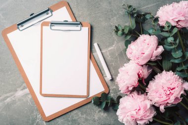 Not defteri, pembe şakayık, mermer arka planda okaliptüs çiçeği olan kadınsı çalışma alanı. Üst görünüm, boşluğu kopyala. Blogcu, kadınsı iş konsepti. Düz yatıyordu. Doğum günü, Kadın Günü. Model.