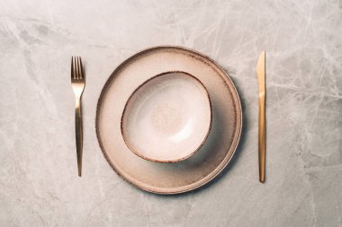 Mermer zemin üzerinde çatal ve bıçak olan taş kaplama seti. Üst Manzara. Uzayı kopyala Düz yatıyordu. Festival masası konseptine hizmet ediyor..