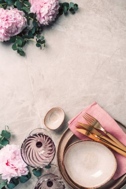 Masadaki çiçek aranjmanı, metin ve davetiyeniz için fotokopi alanı ile servis edilecek. Tebrik kartı. Üst Manzara. Şakayık, okaliptüs, tabaklar, altın çatal bıçak, mermer arka planda şarap kadehleri..