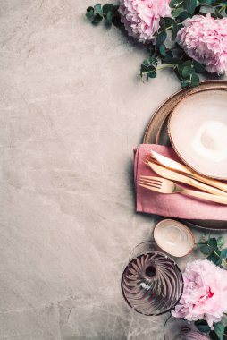 Şakayık, okaliptüs çiçekleri, boş tabaklar, peçete, altın çatal bıçak, şenlik masa servisi için şarap kadehleri mermer zemin üzerinde akşam yemeği. Uzayı kopyala Üst Manzara. Tablo ayarı.