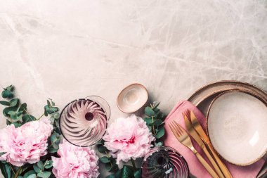 Masadaki çiçek aranjmanı, metin ve davetiyeniz için fotokopi alanı ile servis edilecek. Tebrik kartı. Üst Manzara. Şakayık, okaliptüs, tabaklar, altın çatal bıçak, mermer arka planda şarap kadehleri..