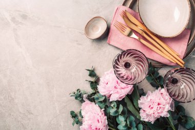 Şakayık, okaliptüs çiçekleri, boş tabaklar, peçete, altın çatal bıçak, şenlik masa servisi için şarap kadehleri mermer zemin üzerinde akşam yemeği. Uzayı kopyala Üst Manzara. Tablo ayarı.