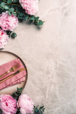 Şakayık, okaliptüs çiçekleri, boş tabaklar, peçete, altın çatal bıçak, şenlik masa servisi için şarap kadehleri mermer zemin üzerinde akşam yemeği. Uzayı kopyala Üst Manzara. Tablo ayarı.