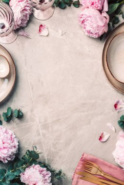 Sofra takımı, şenlik masasına servis edilen çiçekler, akşam yemeği. Taş kaplama tabaklar, altın çatal bıçak takımı, okaliptüs dalları, mermer arka planda şakayık çiçekleri. Uzayı kopyala Düz yerde, üst tarafta. Tablo ayarı.