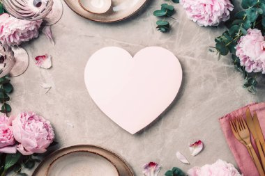 Masadaki çiçek aranjmanı, metin ve davetiyeniz için fotokopi alanı ile servis edilecek. Tebrik kartı. Üst Manzara. Şakayık, okaliptüs, tabaklar, altın çatal bıçak, mermer arka planda şarap kadehleri..