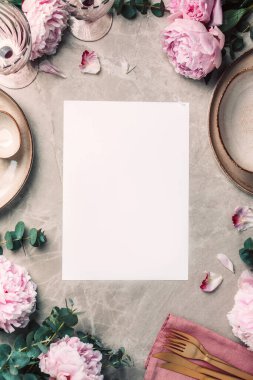 Şakayık, okaliptüs çiçekleri, boş tabaklar, peçete, altın çatal bıçak, şenlik masa servisi için şarap kadehleri mermer zemin üzerinde akşam yemeği. Uzayı kopyala Üst Manzara. Tablo ayarı.