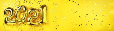 Altın folyo balonları, sarı zemin üzerinde ışık saçan 2021 numaralar yaptı. Banner, boşluğu kopyala. Mutlu yıllar, yeni yıl kutlaması. Selamlar ve tebrikler..