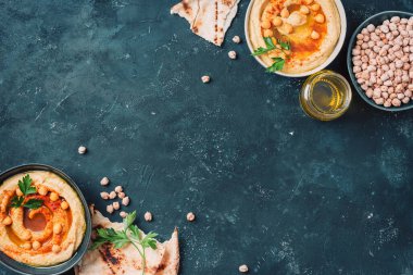 Humus, nohut sosu, zeytinyağı, çiğ fasulye, tütsülenmiş paprika, koyu otantik arka planda pide. Ortadoğu, Yahudi mutfağı ya da Arap yemekleri. Üst Manzara. Uzayı kopyala Vejetaryen, vejetaryen gıda konsepti.