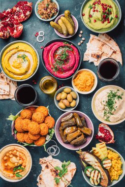 Akdeniz aperatif konsepti. Geleneksel Arap yemekleri. Pide, zeytin, humus, dolma dolma, falafel köftesi, turşu, babaganush, sebze, nar, patlıcan.