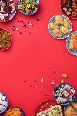 Kırmızı arka planda geleneksel Türk zevki. Üst Manzara. Düz yatıyordu. Uzayı kopyala Arap tatlısı, baklava, halva, rahat lokum, şerbet, fındık, fıstık, hurma, kuru üzüm, kayısı, kilise kilisesi.
