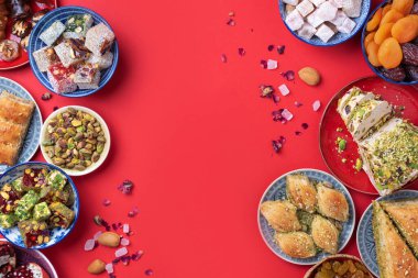 Kırmızı arka planda geleneksel Türk zevki. Üst Manzara. Düz yatıyordu. Uzayı kopyala Arap tatlısı, baklava, halva, rahat lokum, şerbet, fındık, fıstık, hurma, kuru üzüm, kayısı, kilise kilisesi.