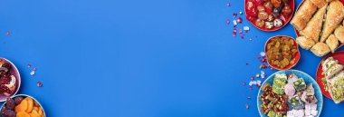 Mavi arka planda Orta Doğu tatlıları. Arap tatlısı, baklava, halva, rahat lokum, şerbet, fındık, şam fıstığı, hurma, kuru üzüm, kayısı, kilise kilisesi, kurabiye. Üst Manzara. Düz yatıyordu. Boşluğu kopyala.