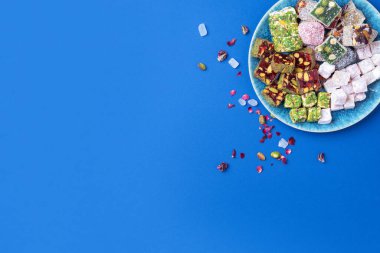 Orta Doğu tatlıları. Mavi arka planda fıstıklı Türk yemeği. Üst Manzara. Uzayı kopyala Arap tatlısı, rahat lokum, şerbet, nugat, kilise kilisesi, kurabiyeler. Düz yatıyordu