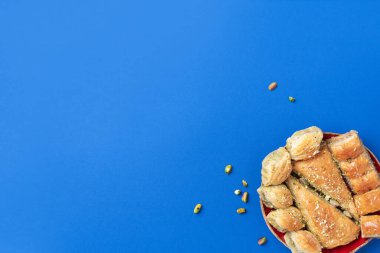 Mavi arka planda fıstıklı Türk tatlı baklavası. Üst Manzara. Uzayı kopyala Geleneksel doğu tatlıları seti. Arap tatlısı, Türk lokumu..