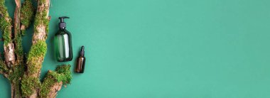 Yeşil arka planda etiketsiz kozmetik şişesi dalların üzerinde doğal yosun, ağaç kabuğu. Cilt bakımı, organik vücut bakımı, spa konsepti. Vegan çevre dostu kozmetoloji ürünü. Organik Kozmetik