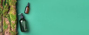 Yeşil cam şampuan, sabun, yeşil arka planda saç kremi ve ağaç kabuğunun üstünde doğal yosun. Üst görünüm, boşluğu kopyala. Model için boş etiket. Cilt bakımı, organik vücut tedavisi, spa konsepti.