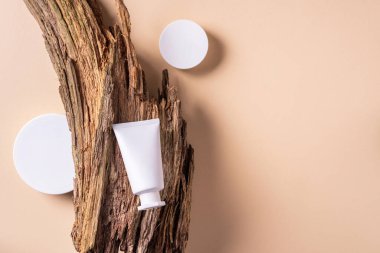 Kuru ahşap kabuk arka planında etiketsiz beyaz kozmetik şişe. Cilt bakımı, organik vücut tedavisi, deri beslenme konsepti. Çevre dostu ürün. Organik kozmetik ürünleri. Nemlendirici, kuru cilt konsepti.