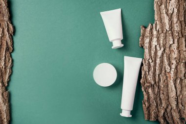 Kuru ahşap kabuk arka planında etiketsiz beyaz kozmetik şişe. Cilt bakımı, organik vücut tedavisi, deri beslenme konsepti. Çevre dostu ürün. Organik kozmetik ürünleri. Nemlendirici, kuru cilt konsepti.
