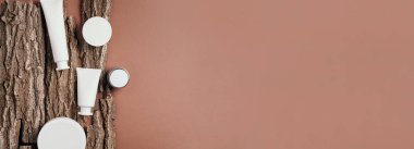 Kuru ahşap kabuk arka planında etiketsiz beyaz kozmetik şişe. Cilt bakımı, organik vücut tedavisi, deri beslenme konsepti. Çevre dostu ürün. Organik kozmetik ürünleri. Nemlendirici, kuru cilt konsepti.