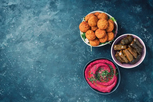 Akdeniz aperatif konsepti. Geleneksel Arap yemekleri. Pide, zeytin, humus, dolma dolma, falafel köftesi, turşu, babaganush, sebze, nar, patlıcan.