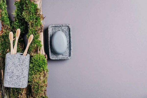 Sıfır atık, plastiksiz, sürdürülebilir konsept. Bambu banyo aksesuarları - sabun tabağı, sabun makinesi, diş fırçası, kişisel hijyen için organik kuru şampuan yeşil yosun dokusu. Uzayı kopyala Üst görünüm