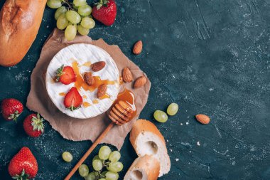 Üzümlü Fransız peyniri, bal, badem, çilek, koyu arkaplanda baget. Üst Manzara. Uzayı kopyala Romantik randevu gecesi. Sevgililer Günü, aşk konsepti. Romantik yemek..