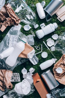 Yiyecek plastik ambalajı, ormanda piknikten sonra yeşil yosun arka planında çöp. Üst Manzara. Uzayı kopyala Plastik geri dönüşümü. Çevre kirliliği, ekoloji kavramı. Çöpü, geri dönüşümü, plastiği yeniden kullan