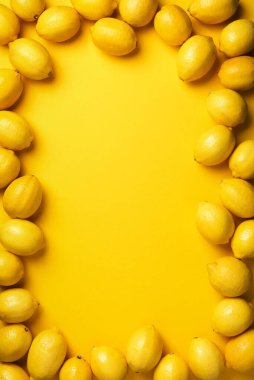 Sarı arka planda limon çerçevesi. Bağışıklık sistemi güçlendirici. Uzayı kopyala Üst Manzara. Düz yatıyordu. Turunçgil meyvesi. Sağlık için vitaminler. Vejetaryen alkalin diyeti için liposomal C vitamini..