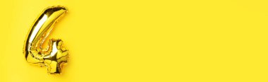 Yaratıcı düzen. Altın folyo balon numarası ve 4 haneli rakam. Doğum günü tebrik kartı. Yıldönümü konsepti. Üst Manzara. Uzayı kopyala Sarı arkaplan üzerinde zarif altın rakam. Sayısal rakam