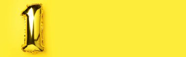 Yaratıcı düzen. Altın folyo balon numarası ve sayı 1 1. Doğum günü tebrik kartı. Yıldönümü konsepti. Üst Manzara. Uzayı kopyala Sarı arkaplan üzerinde zarif altın rakam. Sayısal rakam.