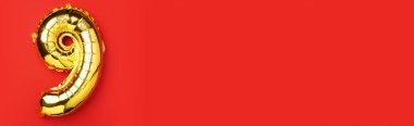 Yaratıcı düzen. Altın folyo balon numarası ve 99. rakam. Doğum günü tebrik kartı. Yıldönümü konsepti. Üst Manzara. Uzayı kopyala Kırmızı zemin üzerinde zarif altın rakam. Sayısal rakam