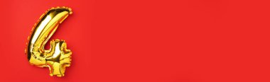 Yaratıcı düzen. Altın folyo balon numarası ve 4 haneli rakam. Doğum günü tebrik kartı. Yıldönümü konsepti. Üst Manzara. Uzayı kopyala Kırmızı zemin üzerinde zarif altın rakam. Sayısal rakam