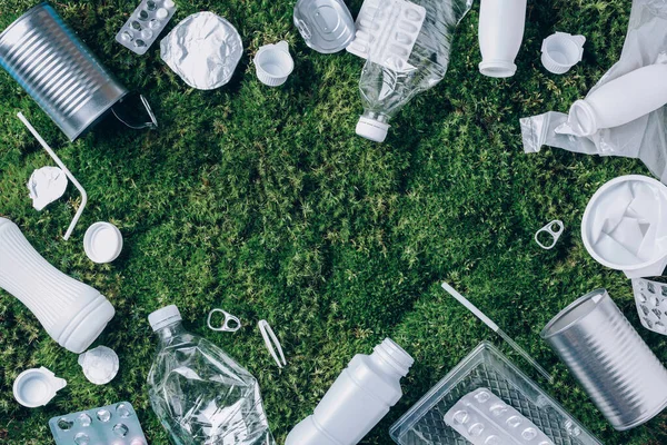 Food plastic packaging, trash on green moss background after picnic in forest. Top view. Copy space. Recycling plastic. Environmental pollution, ecology concept. Reuse garbage, recycle, plastic free