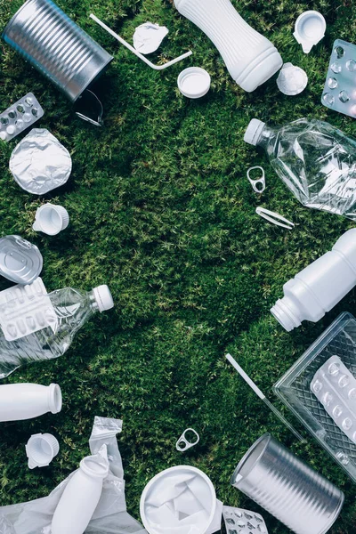 Plastic waste, food packaging, trash collection on green moss background after picnic in forest. Plastic free. Top view. Copy space. Recycling plastic. Environmental pollution, ecology concept