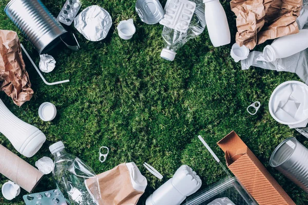 Plastic waste, food packaging, trash collection on green moss background after picnic in forest. Plastic free. Top view. Copy space. Recycling plastic. Environmental pollution, ecology concept