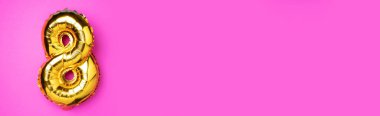 8 Mart. Mutlu Kadınlar Günü. Yaratıcı düzen. Altın folyo balon numarası, rakam sekiz sekiz. Doğum günü tebrik kartı. Yıldönümü konsepti. Üst Manzara. Pembe arka planda altın rakam. Sayısal rakam.
