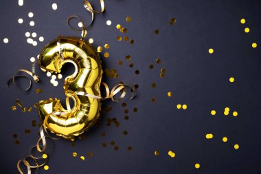 Altın folyo balon numarası ve 3 haneli rakam. Doğum günü tebrik kartı. Yıldönümü kutlaması. Pankart. Uzayı kopyala Şık altın rakamlı, açık renkli, parlak, siyah arkaplan. Sayısal rakam