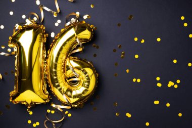 Altın folyo balon numarası, sayı 16. Doğum günü tebrik kartı, 16. yazı. Yıldönümü kutlaması. Pankart. Şık altın rakamlı, açık renkli, parlak, siyah arkaplan. Sayısal rakam.