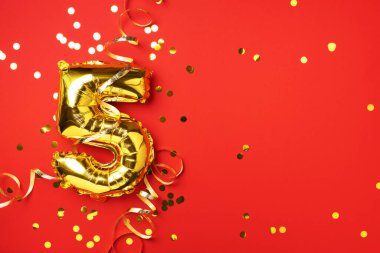 Altın folyo balon numarası ve rakam 5-5. Doğum günü tebrik kartı. Yıldönümü kutlaması. Pankart. Uzayı kopyala Şık altın rakamlı, parlak parıltılı, kırmızı arkaplan. Sayısal rakam